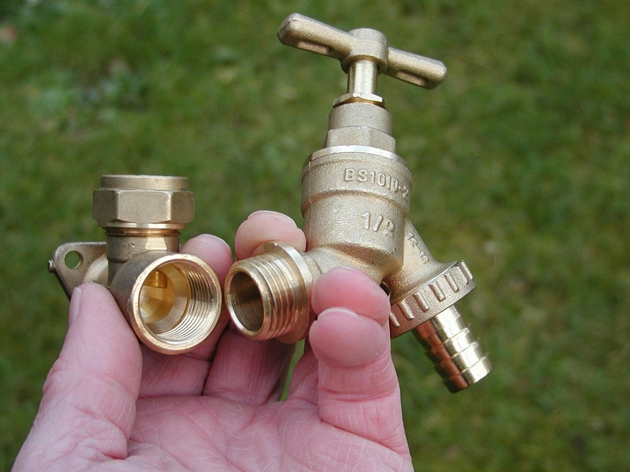 Plumber holding brass tap and valve fittings
