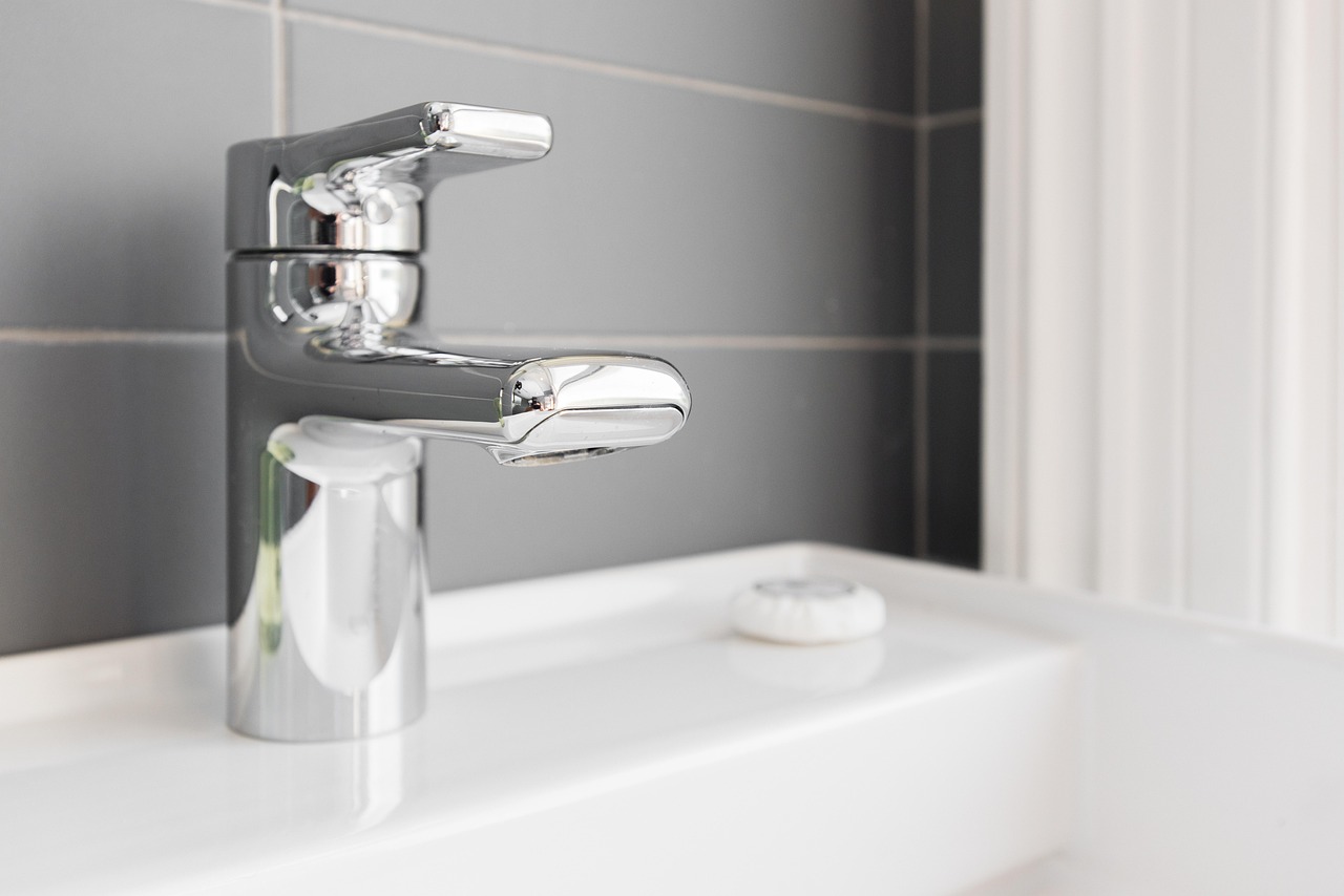 Chrome basin mixer tap on a white sink